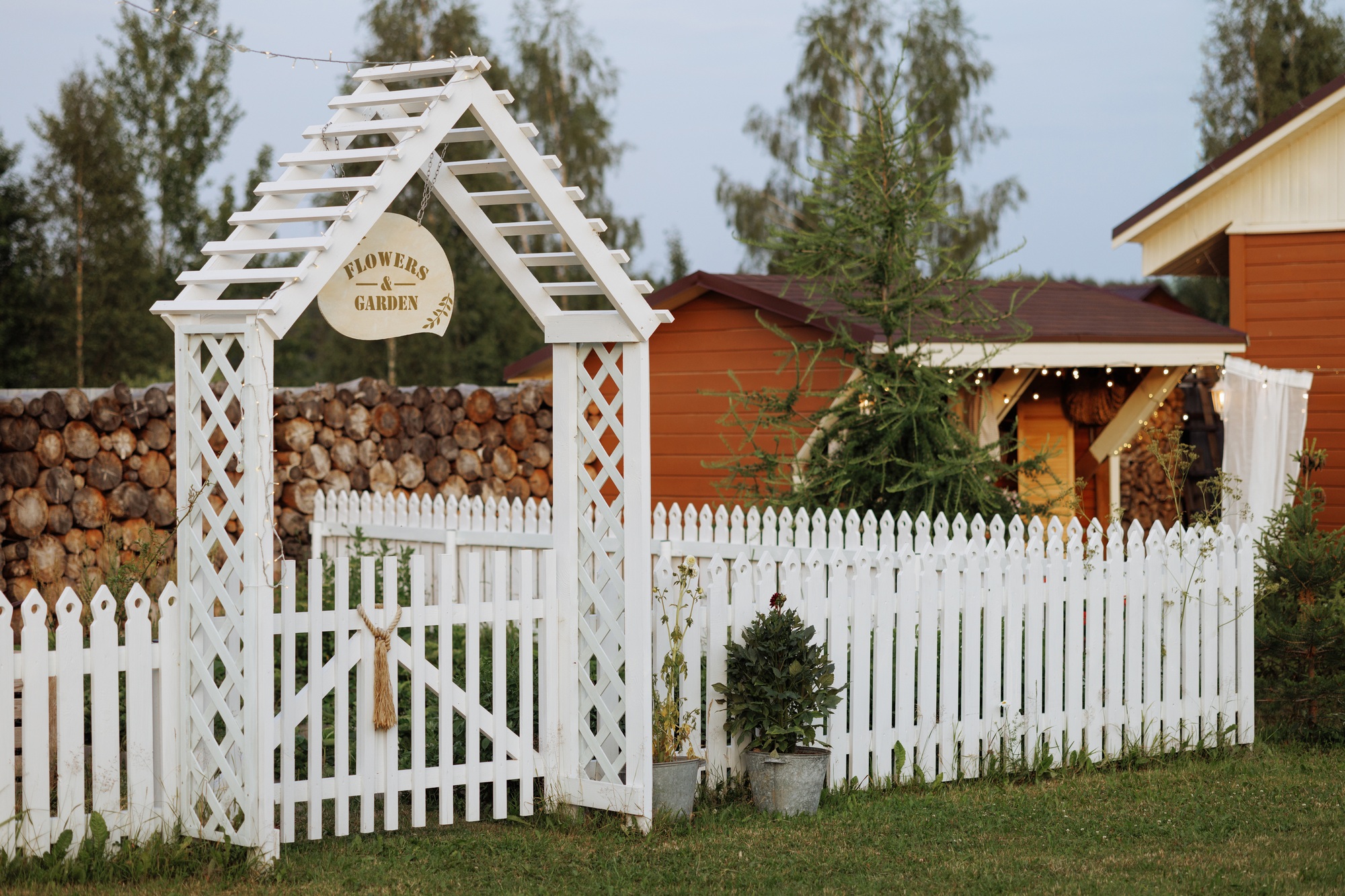 Cozy home garden with white fence and flowers.